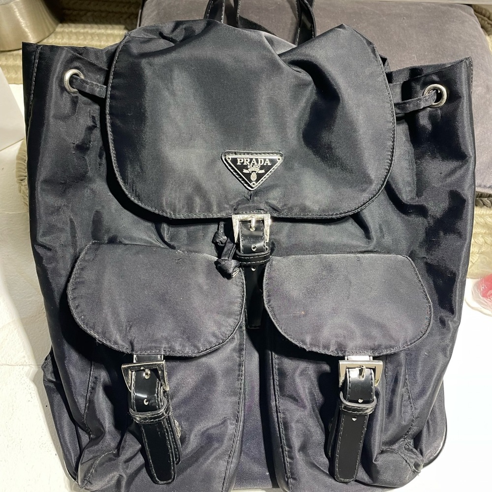 Triangle Logo Patched Buckled Backpack from Prada. Color: black